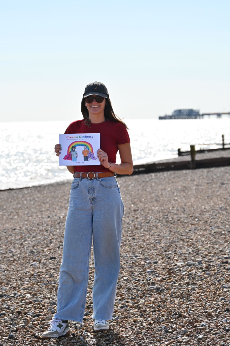 The author with her Corona Kindness book on a beach