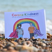 Corona Kindness book on a beach
